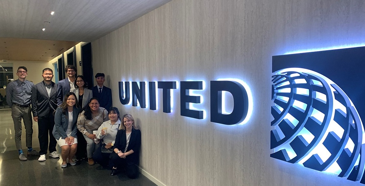 Students in front of the United sign at corporate headquarters. 