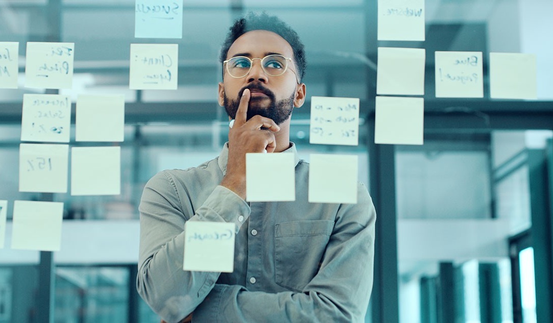 Employee staring at a wall of post-it notes. 